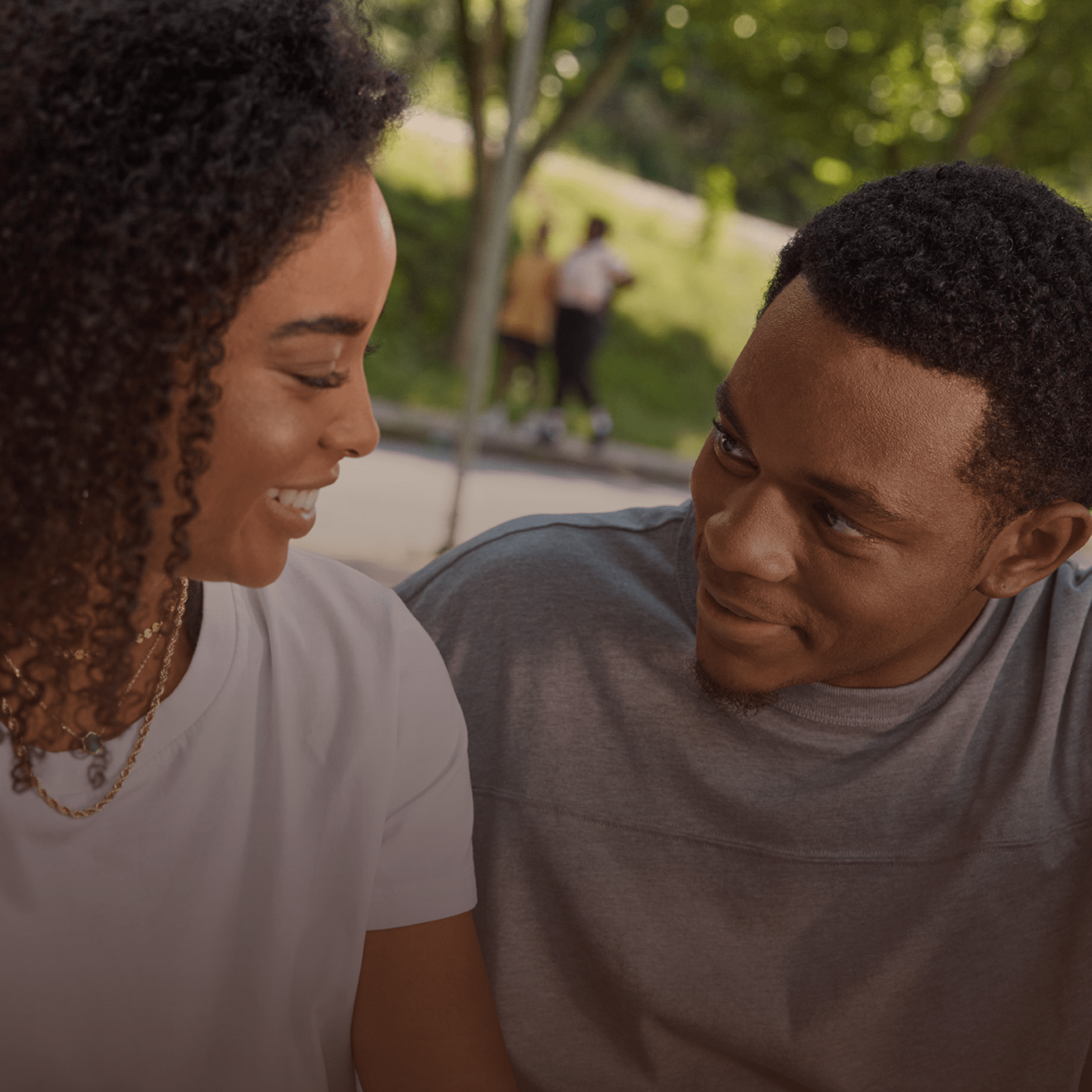 A black couple is speaking with each other at the 
park