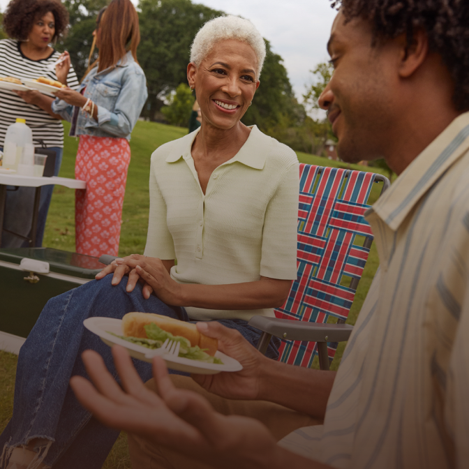Two Black women are talking at the park.